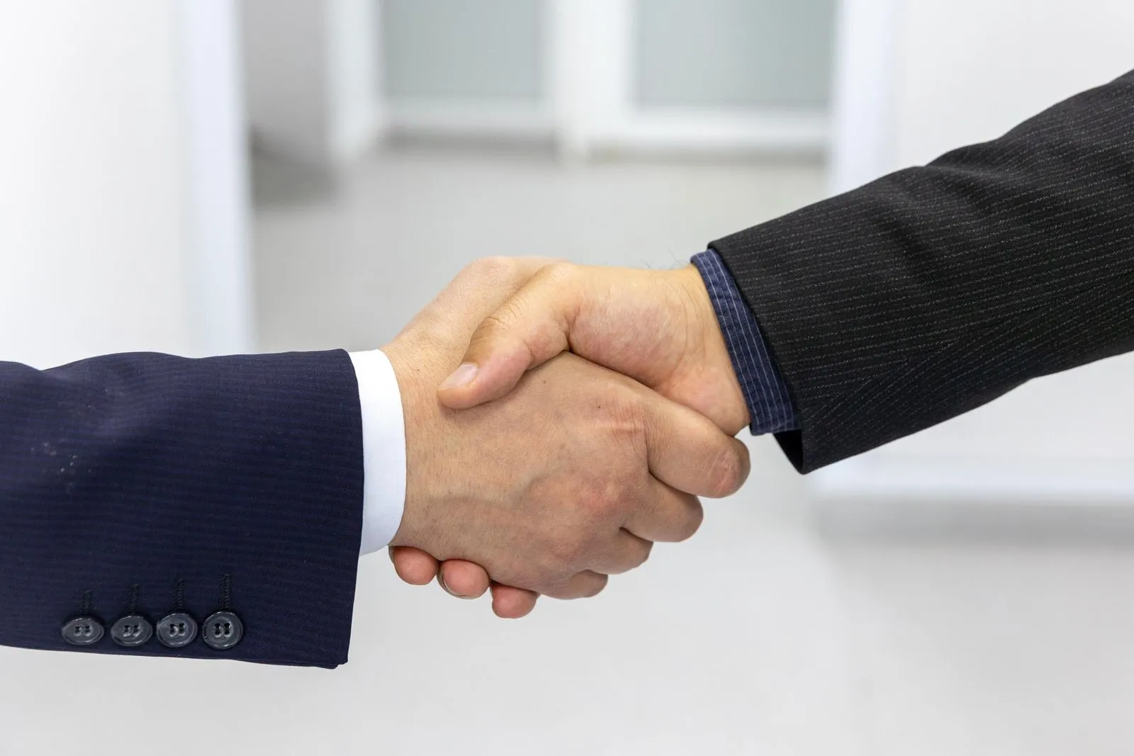 Two people in business dress shaking hands